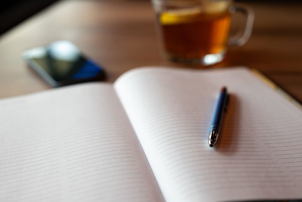 Notebook, pen and smartphone on a table used for planning a message