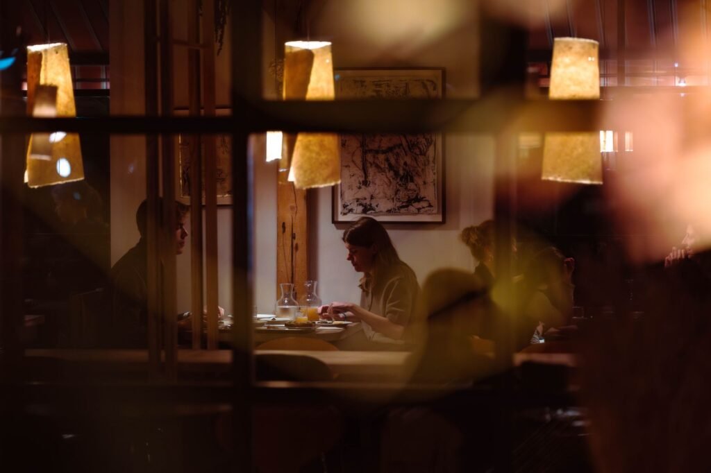 Two adults in conversation at a table in a warmly lit venue