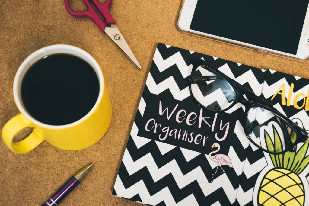 Notebook, phone and coffee on a table during quiet evening planning