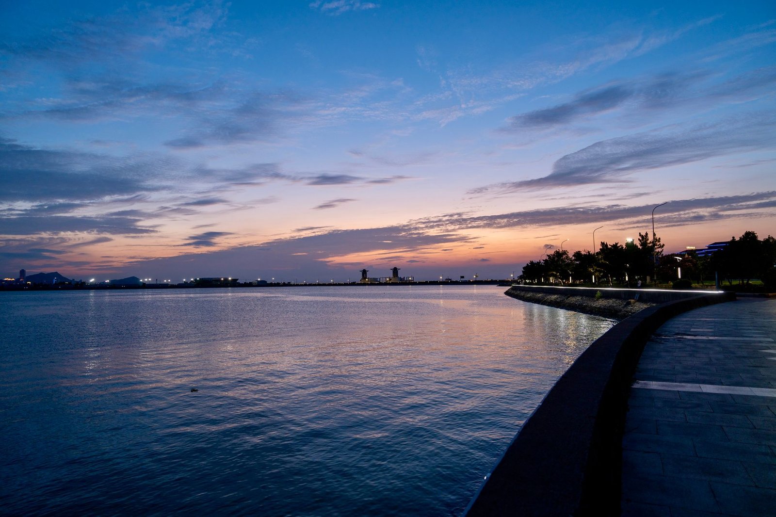 Quiet coastal promenade in a South African suburb at dusk with warm streetlights