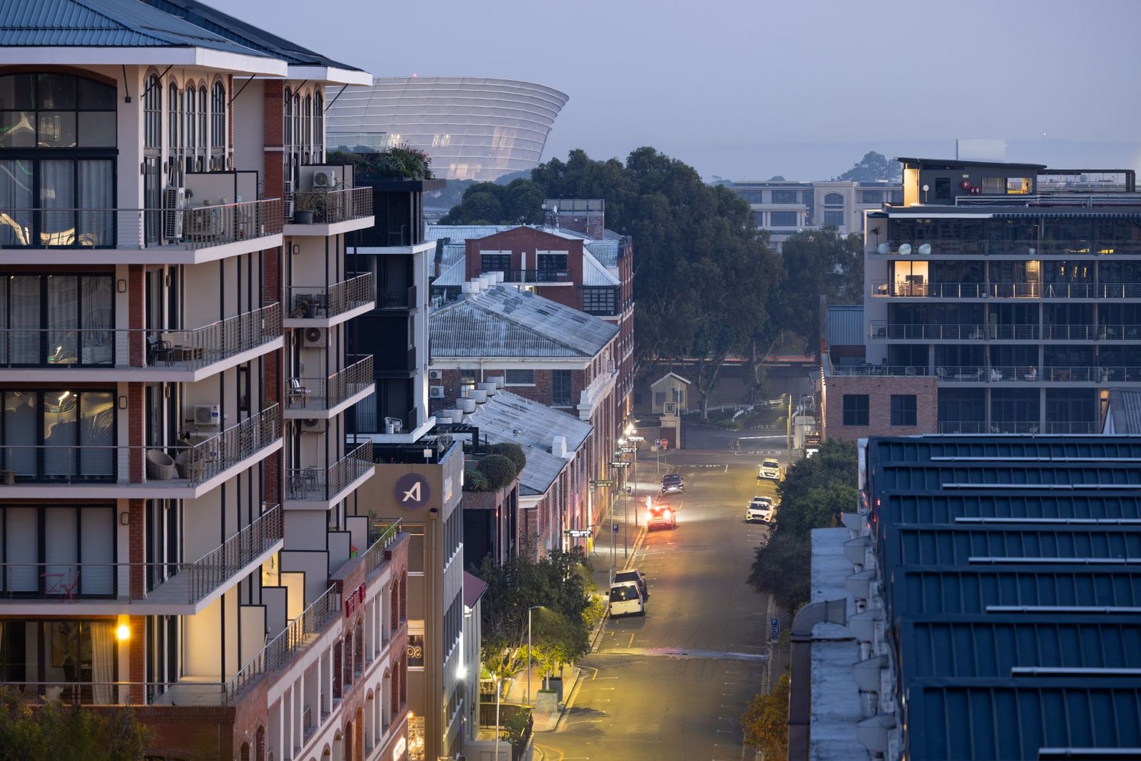 Quiet Bloemfontein street at dusk with a traveller walking past historic buildings