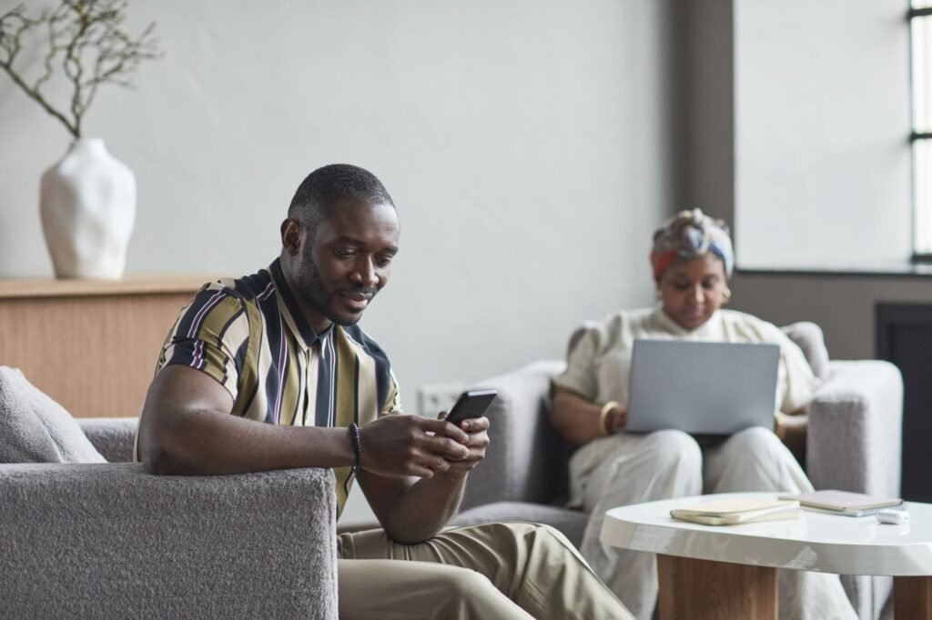 Person composing a message on a smartphone at a hotel lobby table