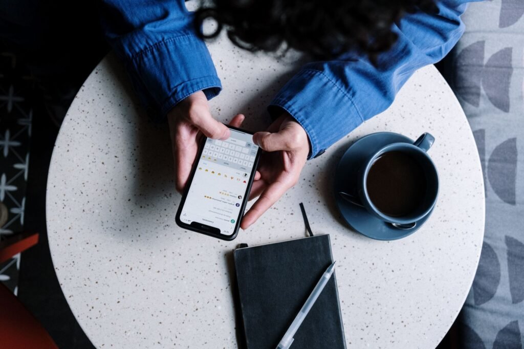 Person composing a clear introductory message on a smartphone at a table
