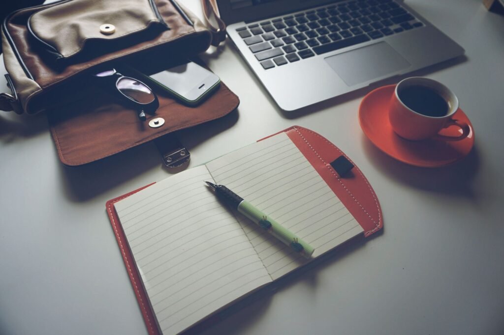 Smartphone, notebook and coffee on a table during booking planning