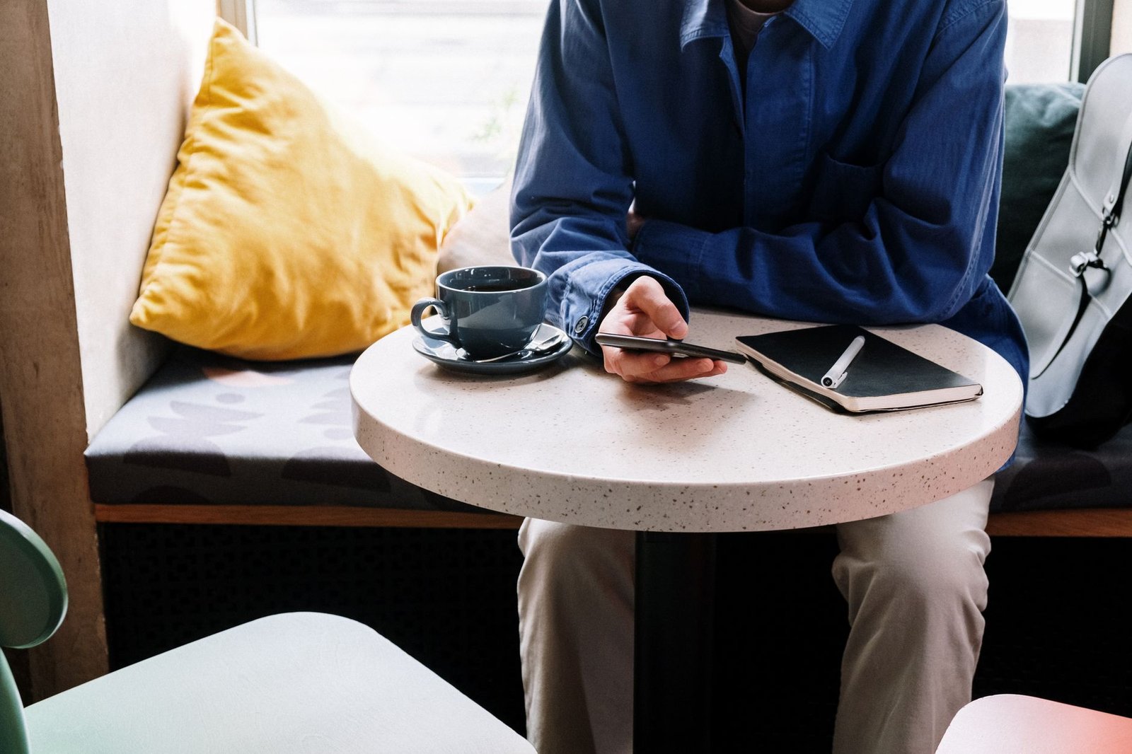 Notebook, coffee and smartphone on a cafe table in soft daylight