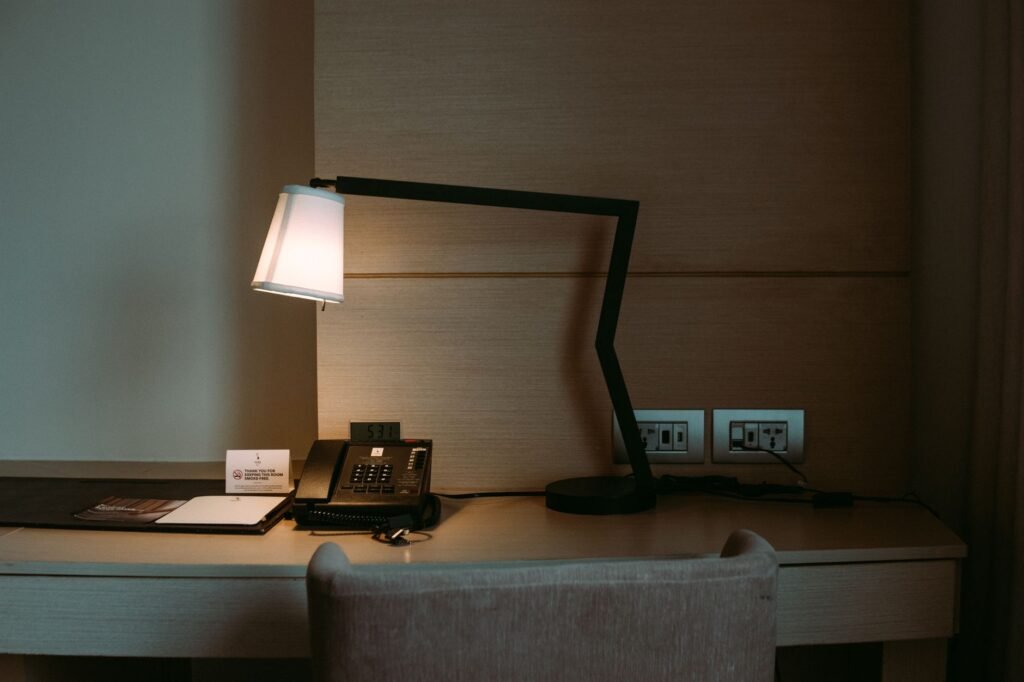 Hotel room desk with a smartphone and notebook, used for planning a discreet booking