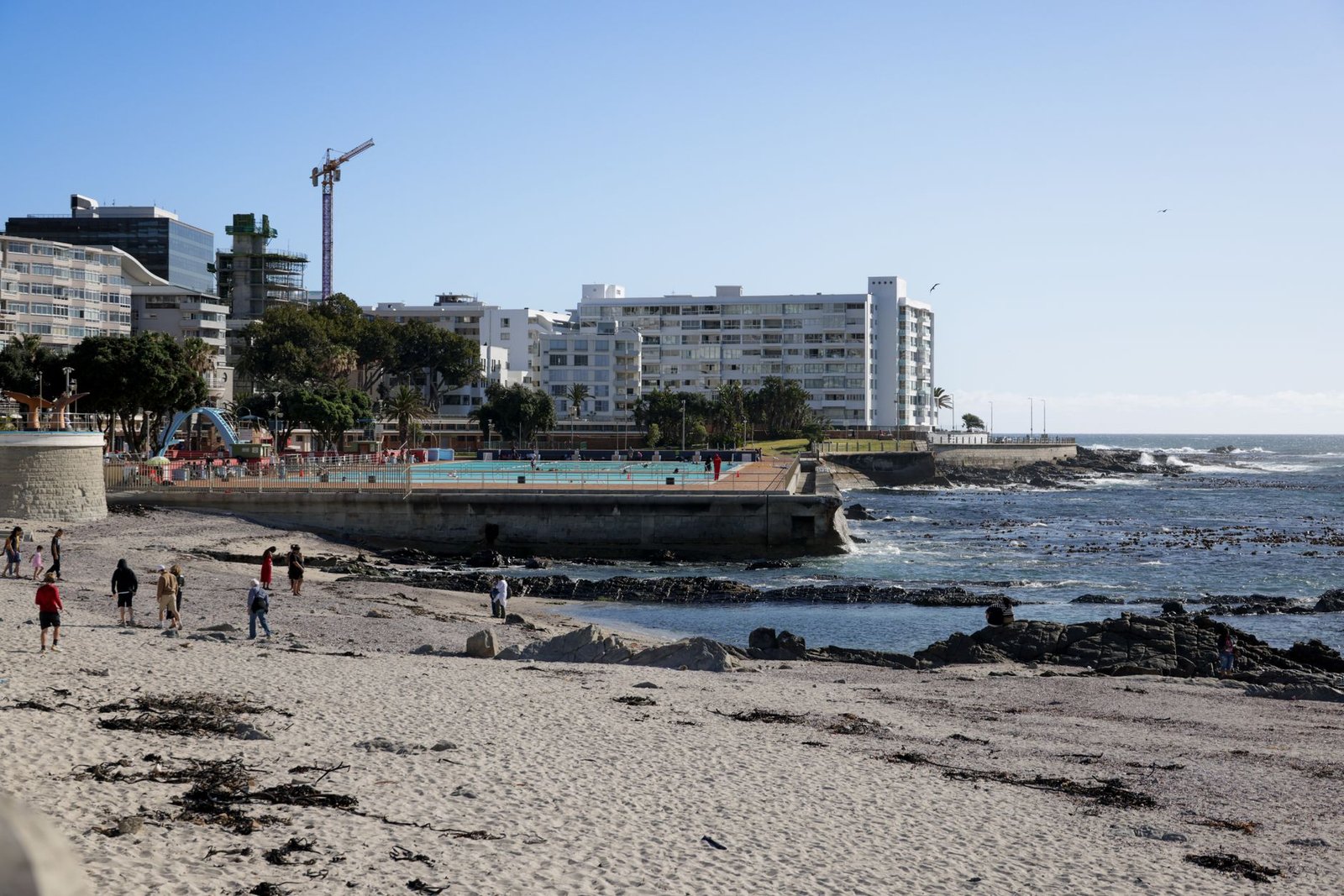 The Sea Point Promenade in Cape Town at golden hour, with the Atlantic Ocean and city slopes behind